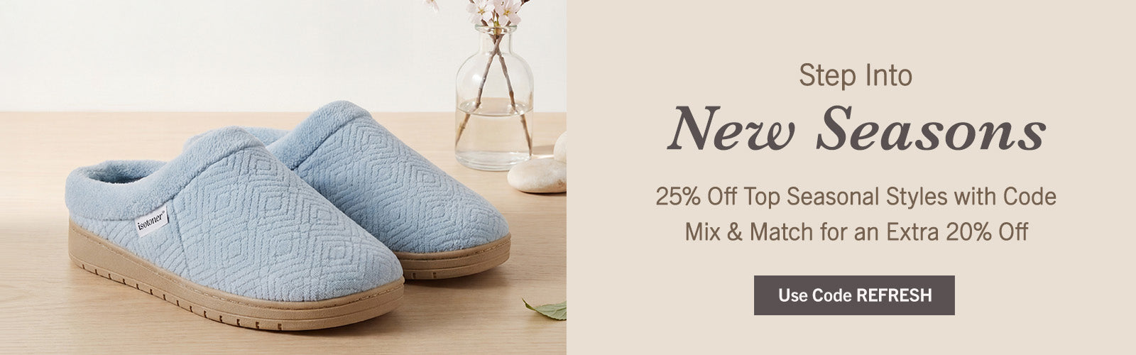A pair of light blue quilted slip-on house slippers with tan soles, displayed on a light wood surface next to a glass vase. The right side of the image features a promotional banner with the text 'Step Into New Seasons' and a 'Use Code REFRESH' button.