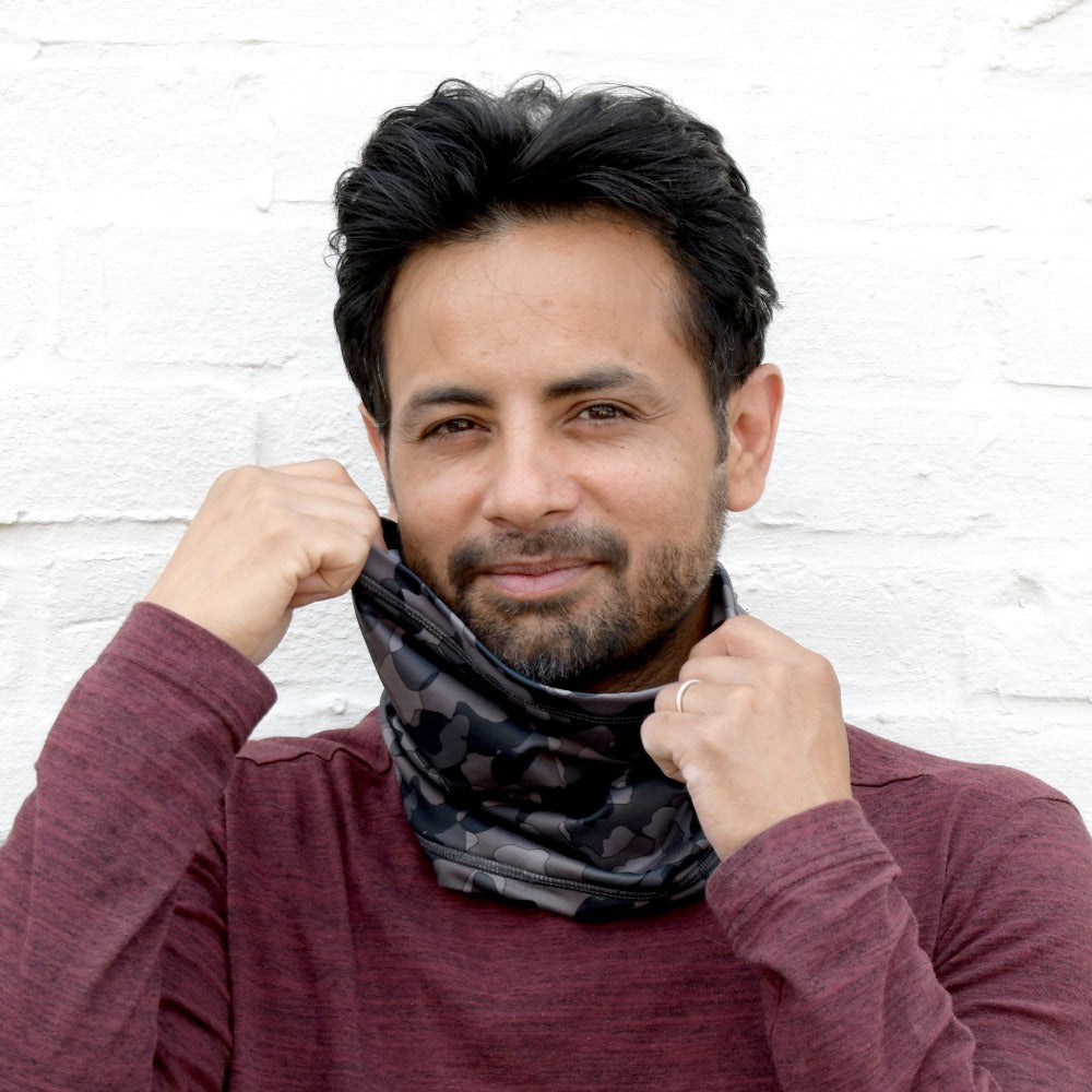 Men’s Antimicrobial Fleece Gaiter in Black Camo on figure. Model pulling up the sides of the gaiter and smiling