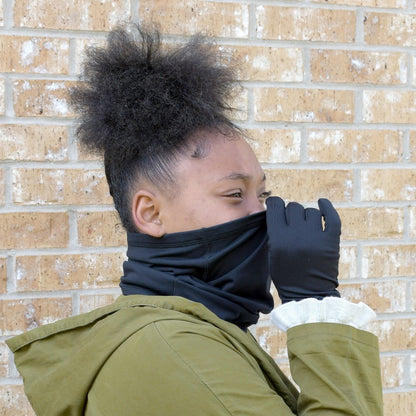 Women’s Lined Antimicrobial Gaiter in Black on figure. Model pulling the gaiter over her nose
