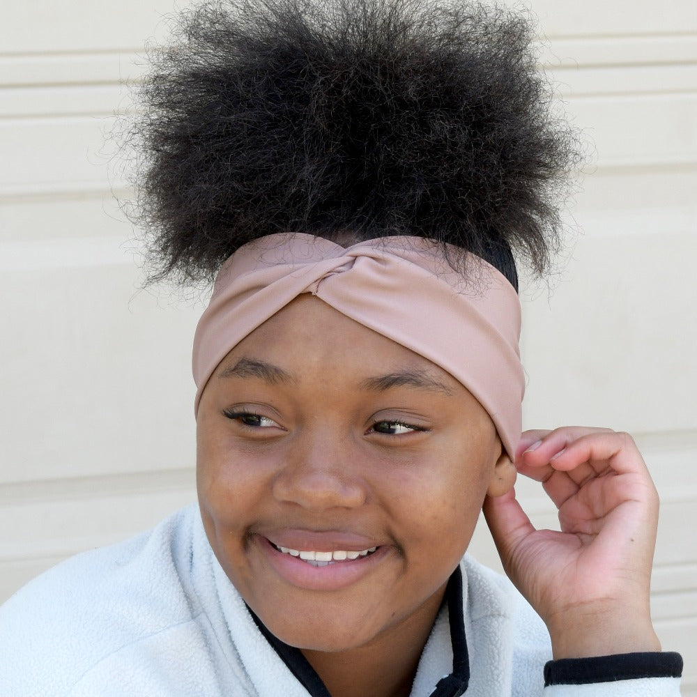 Women’s Recycled Water Repellent Spandex Twist Headband in Winter Blossom on figure. Model wearing headband, smiling.